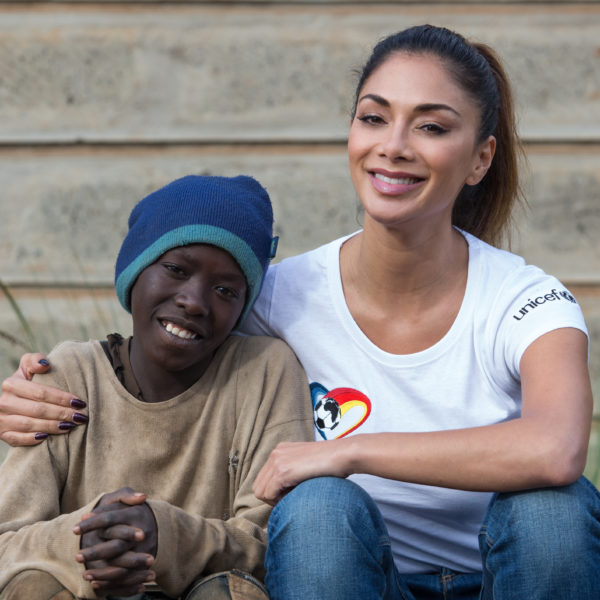 Unicef UK High Profile Supporter Nicole Scherzinger with 12-year-old George at the UNICEF supported centre (AMREF) in Dagoretti sub-county. Children come for a hot meal, clean water and a safe place to play and learn. 60,000 children are living or working on the streets of Nairobi in Kenya, facing dangers like violence, disease and exploitation every day. UNICEF and its partners are working around the clock to provide vital support and offer a lifeline for children in danger. Dagoretti sub-county in Nairobi,