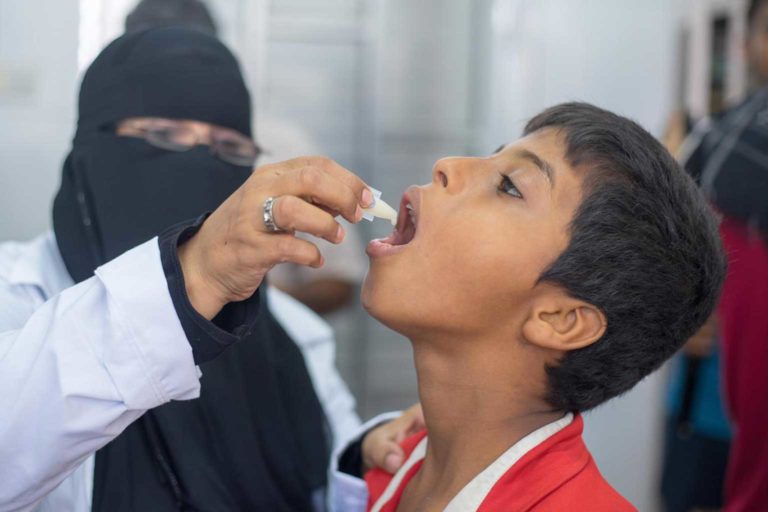 Emergency staff give a boy a cholera vaccine in Yemen