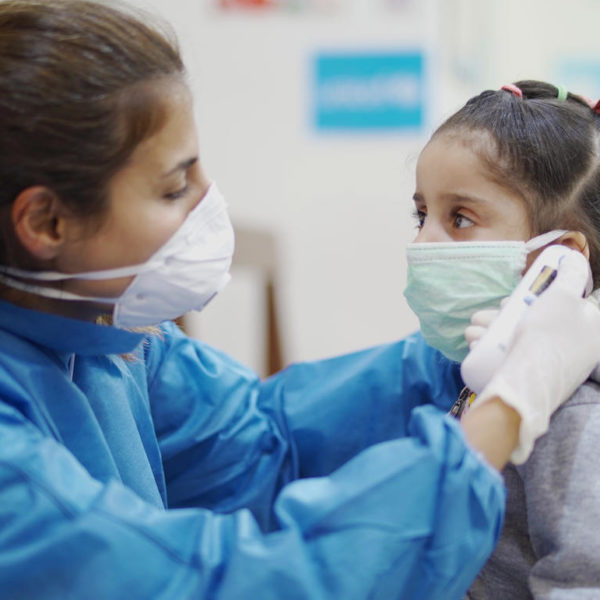Girl being assisted with wearing a mask